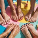 a group of feet with painted bright summer nails