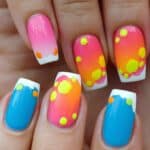 Bright pink and blue acrylic nails with a fun polka dot design and white French tips.