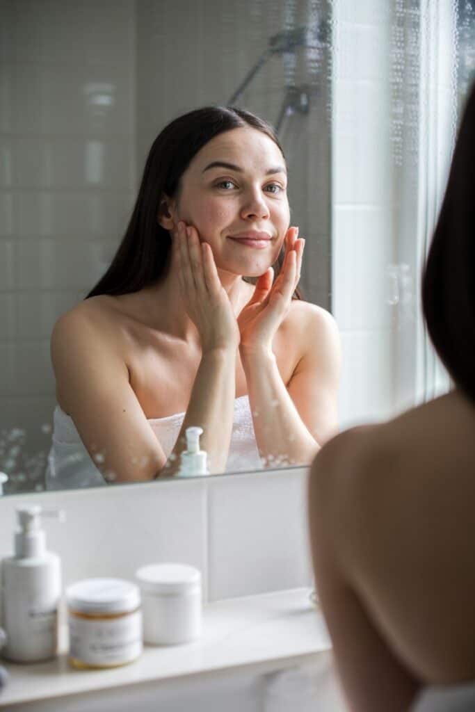 a woman in a towel touching her face