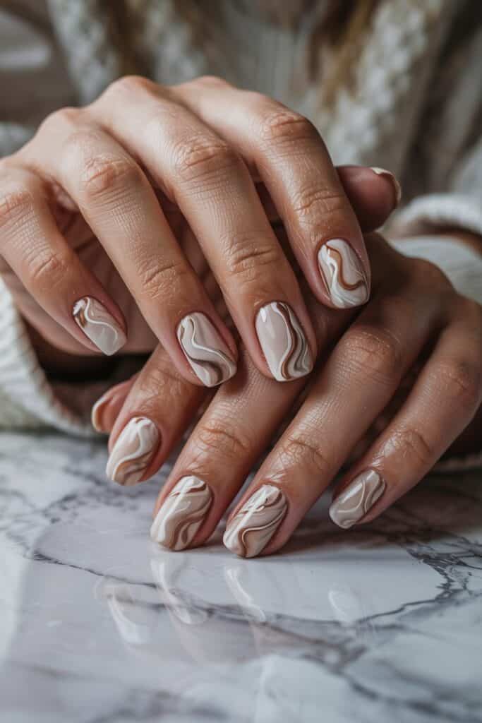 Latte swirl marble nail art on short nails featuring diagonal placement for an elongating effect.