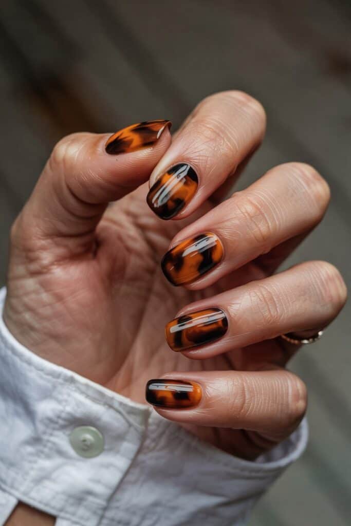 8. **Tortoiseshell Burnt Orange**: Tortoiseshell pattern in burnt orange and brown tones on oval-shaped nails.
