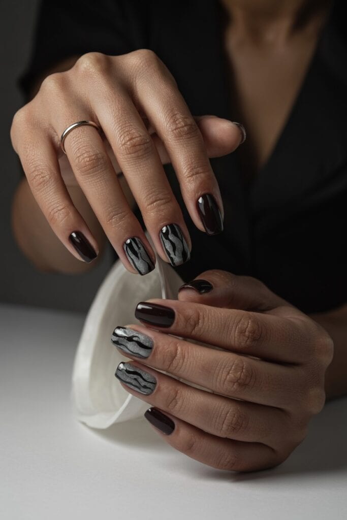 Short matte black nails with glossy drip details creating a spooky Halloween effect.
