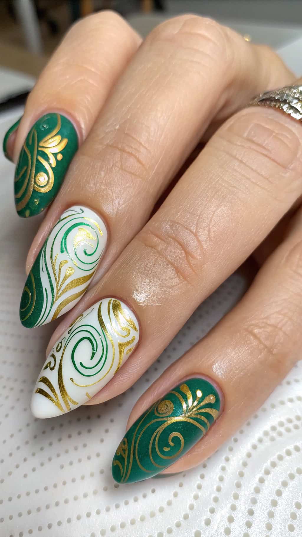 Abstract nail art in forest green and gold with white accents