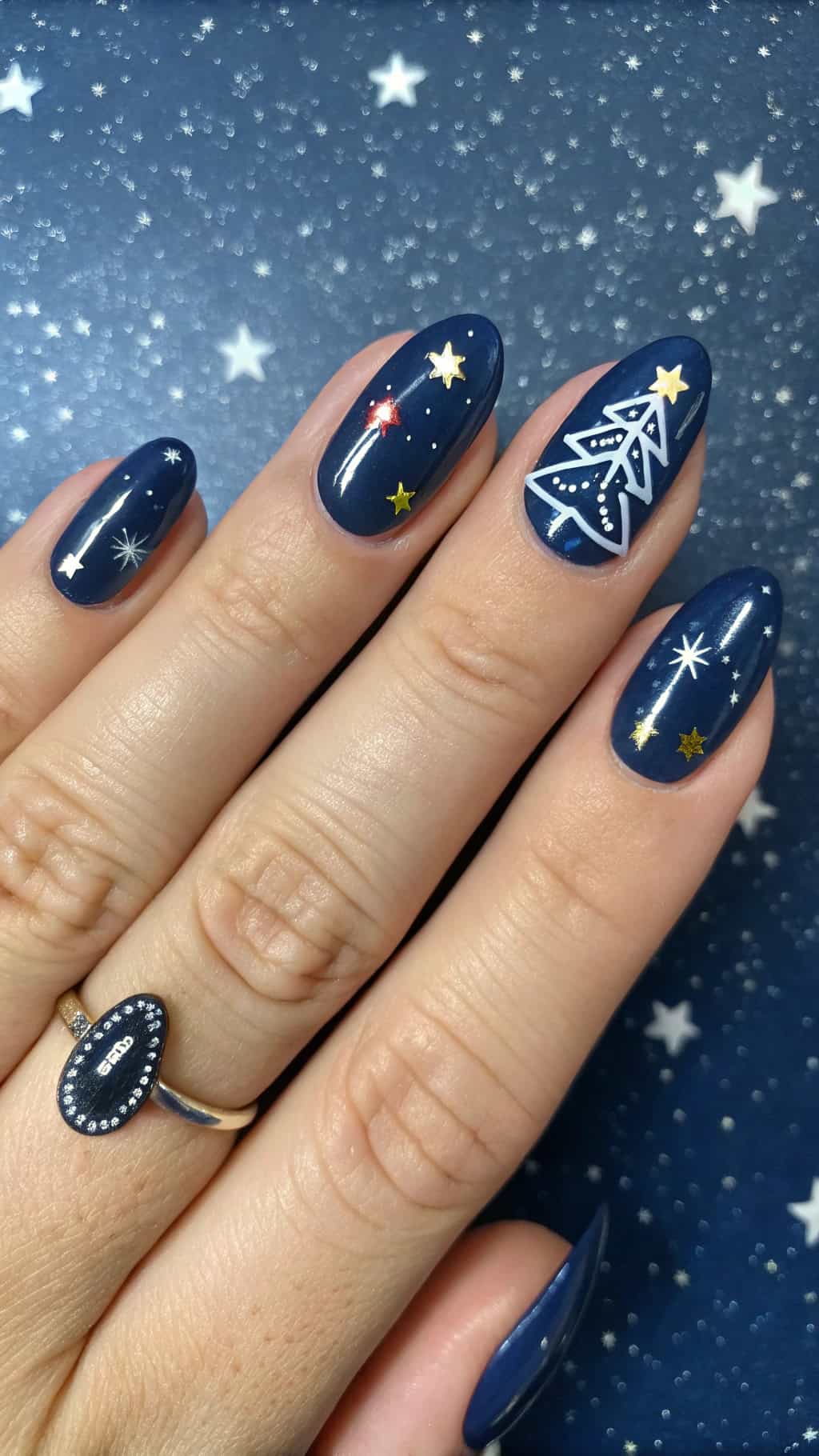 Nail design featuring a starry night sky with Christmas lights and a tree.