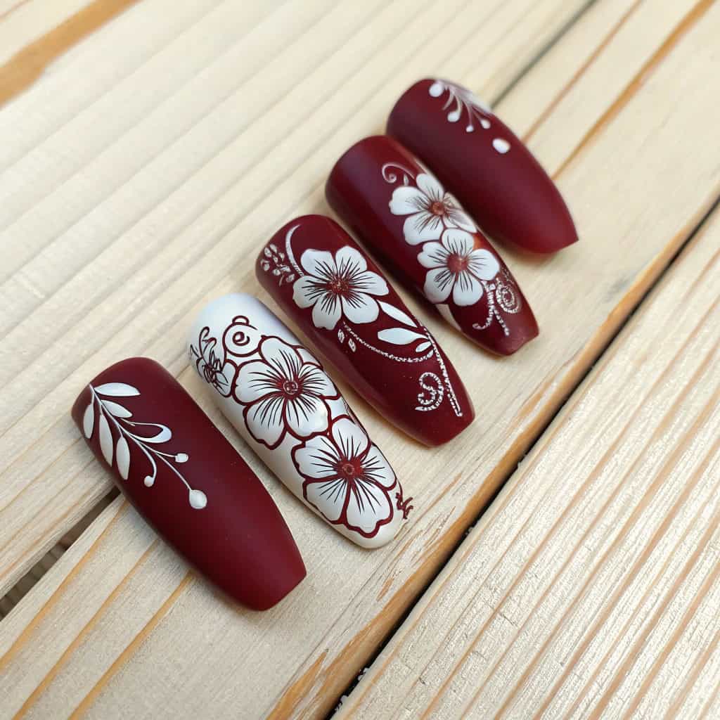 Floral dark cherry red nail art with white flower designs